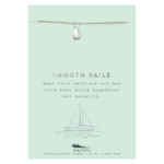Lucky Feather Sailboat Necklace on display card reading "Smooth sails wear this necklace and may calm seas bring happiness and serenity". Silver necklace with sailboat charm on nylon cord.