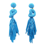 Blue Beaded Knot Post Statement Earrings shown on white background. Post earring is made with blue seed and bugle beads and is in a knot pattern with beaded fringe hanging down below the knot.